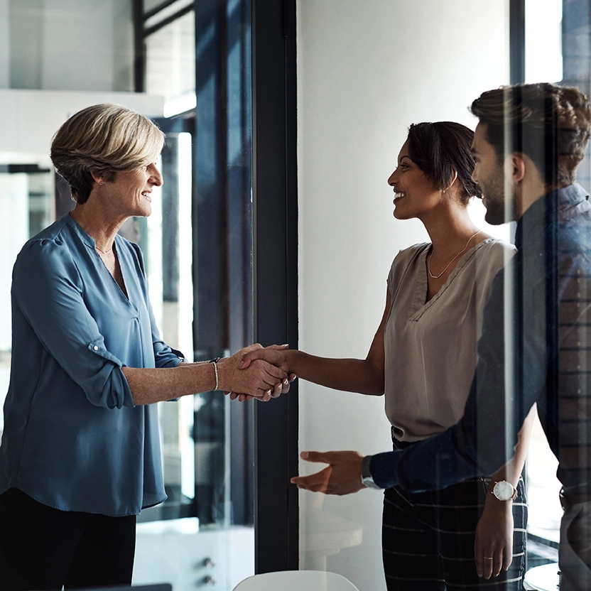 Three people talking to each other shaking hands