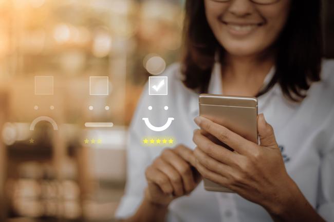 A customer rates a business with a smiley face, good customer experience Positive customer experience CX smiley face good rating